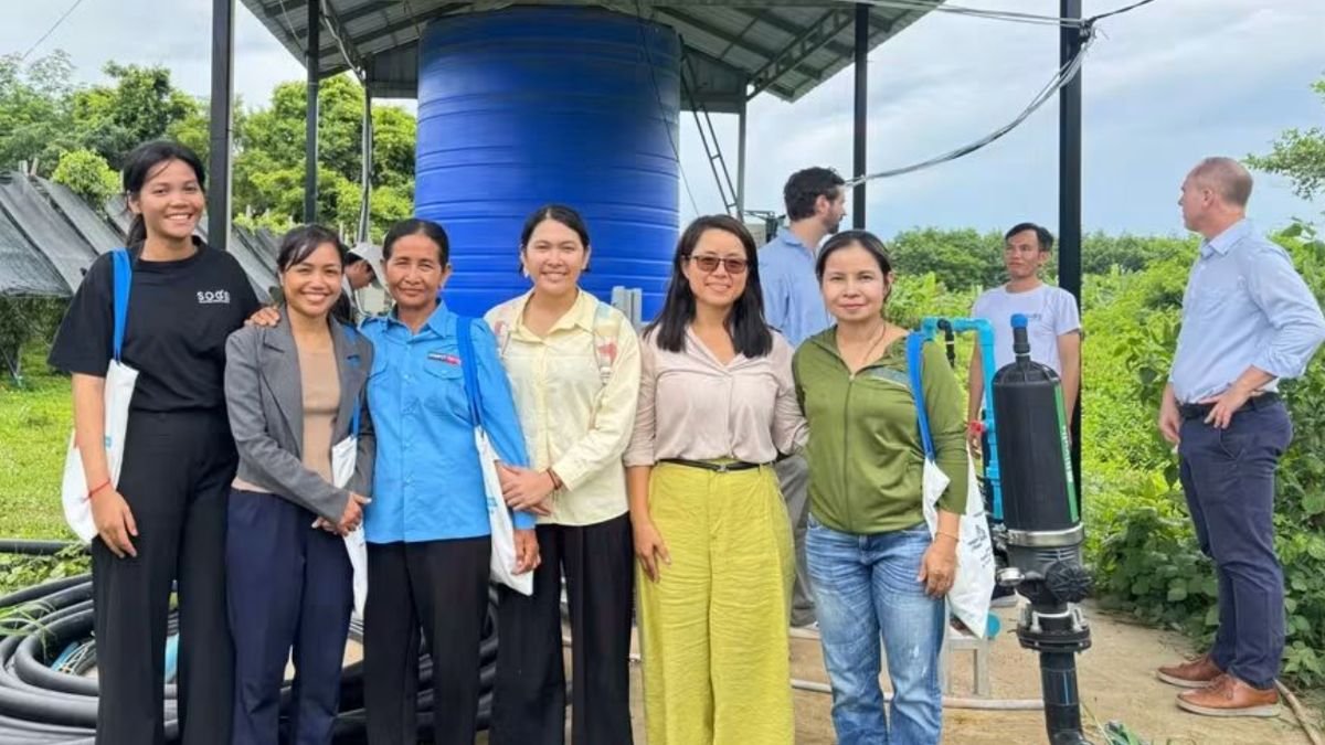 Project partners in front of the irrigation water tank on the farm