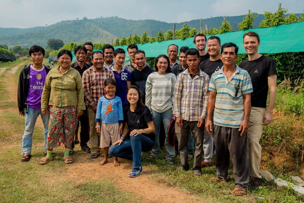 Grower partners and the Fair Farms team standing together at the edge of a pepper field in Kampot